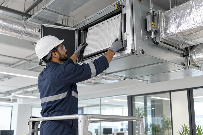 Technician replacing an air-handling unit filter