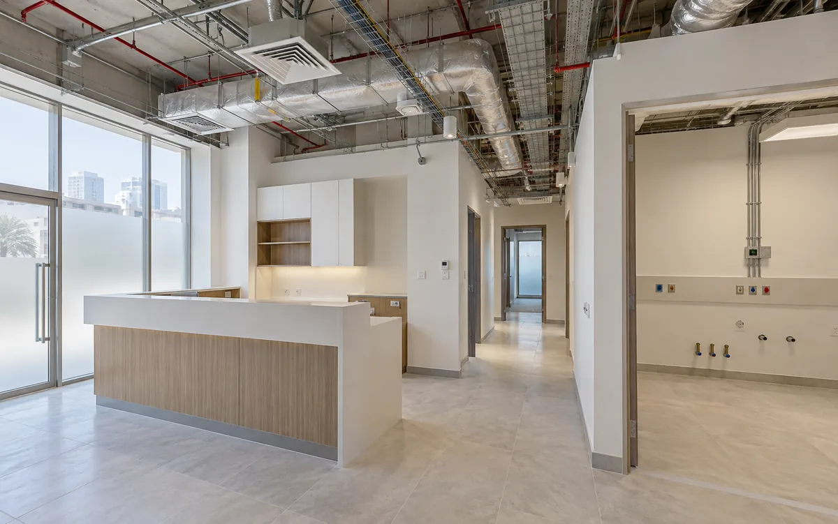 Clinic fit-out with exposed coordinated ceiling services and plumbing rough-in